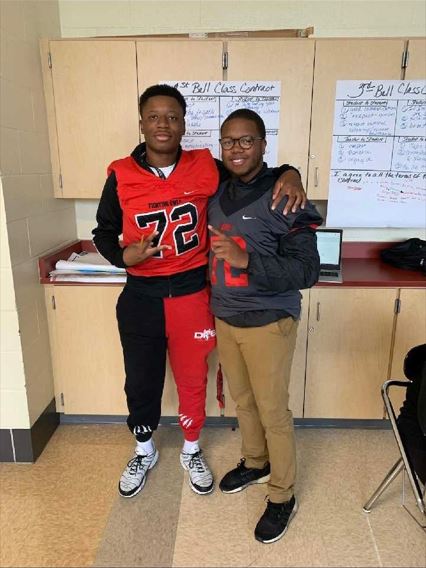 Student and Mt Healthy High School staff member posing with jerseys