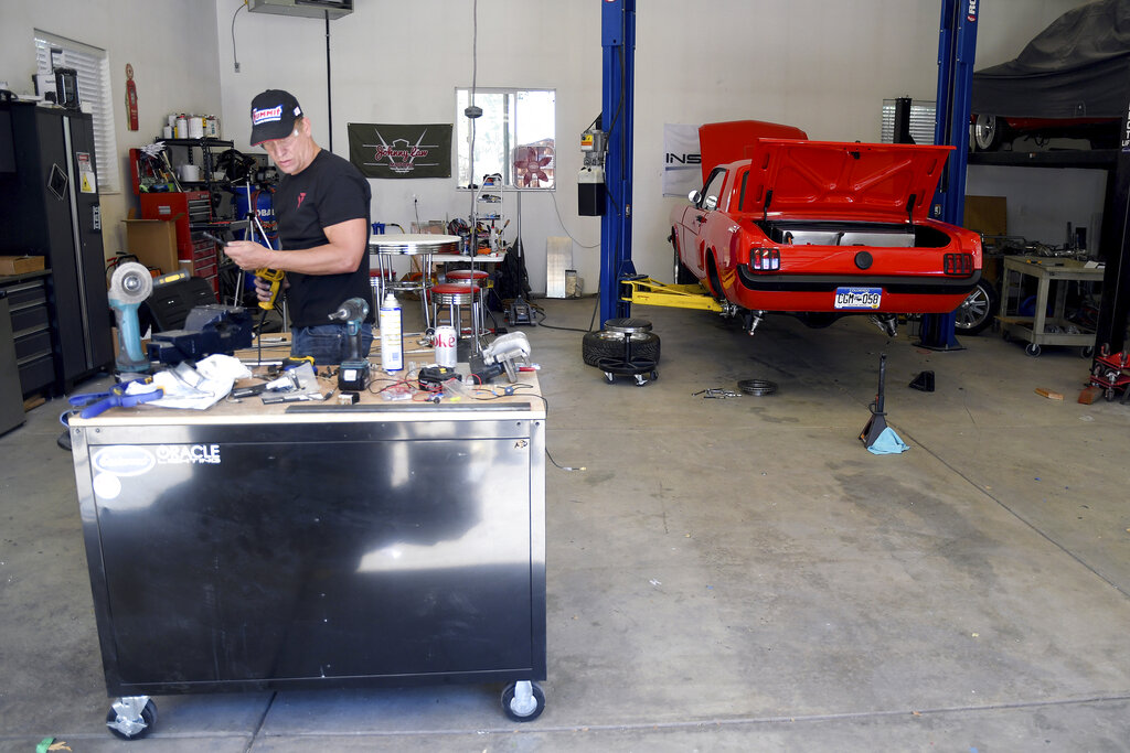 Sean Moudry, co-owner of Inspire EV, works on an electrified 1965 Ford Mustang in Arvada, Colo.
