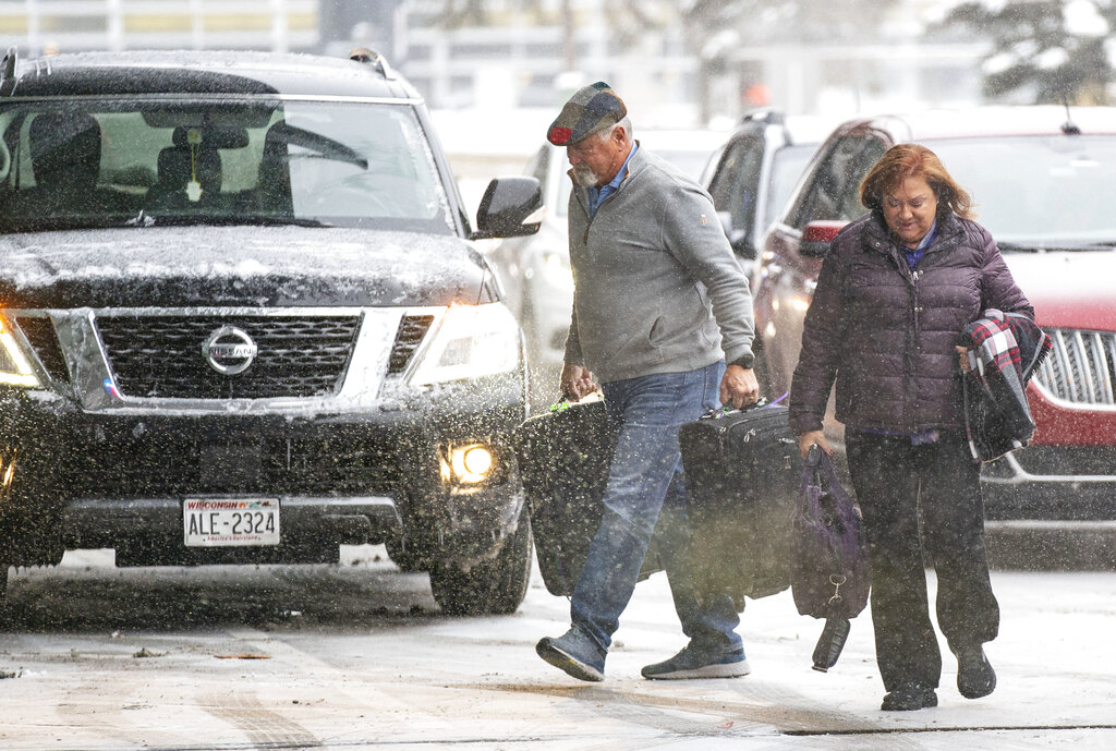 Travelers walk through the snow into Terminal 1 at the Minneapolis-Saint Paul International Airport