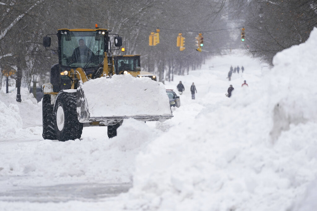 Workers use heavy equipment to clear snow in Buffalo, N.Y.