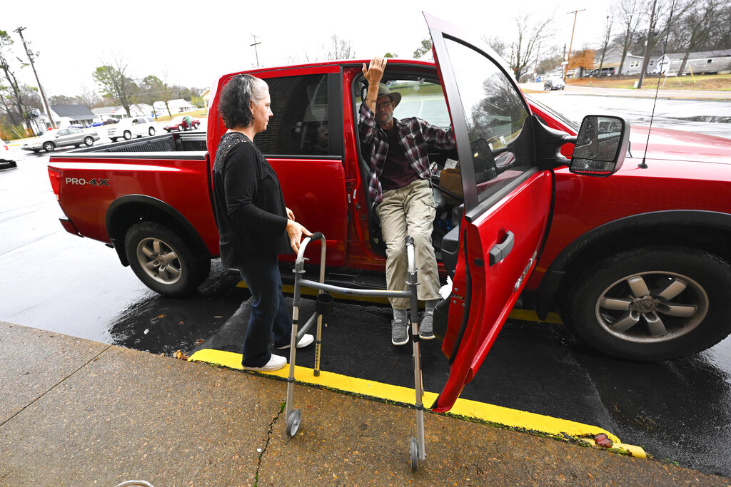 Jerry Lamb, who has a spine condition, gets out of his truck while his wife, Laura, waits to assist him as they arrive at Camden First United Methodist Church