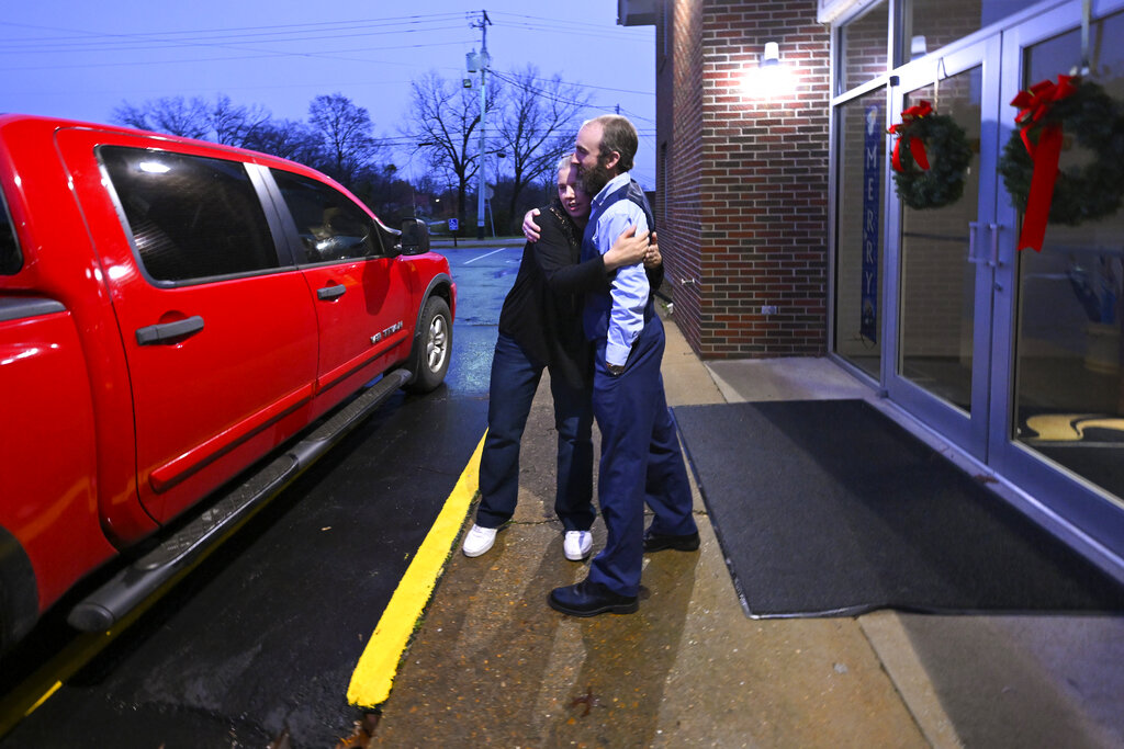 Laura Lamb, left, hugs Pastor Adam Kelchner after helping her husband, Jerry, who has a spine condition, into their truck while leaving Camden First United Methodist Church