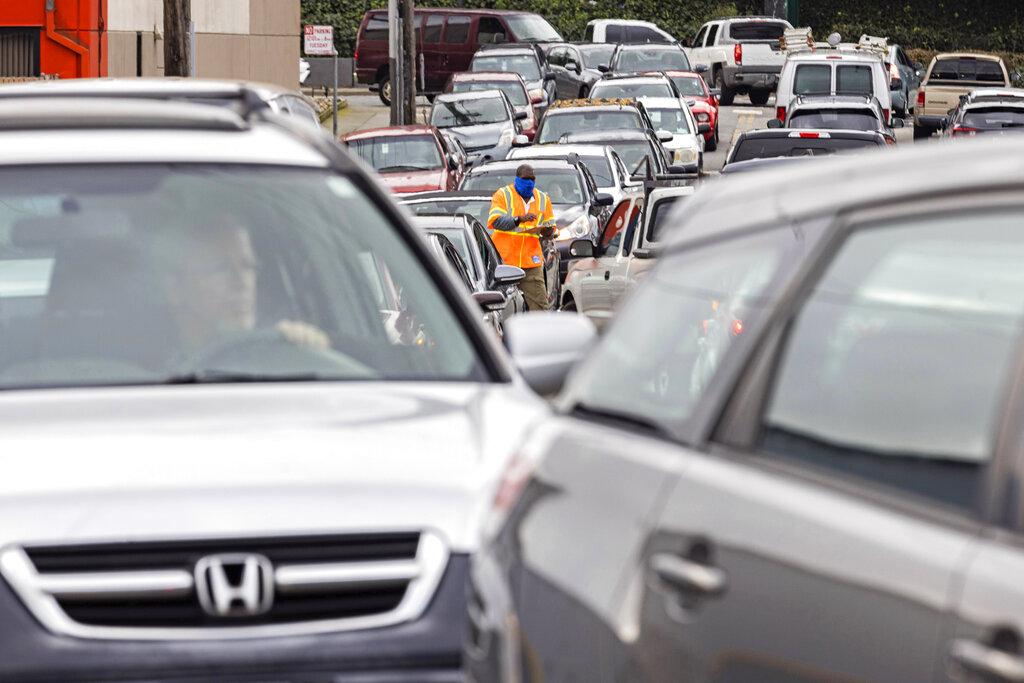 People line up in their vehicles as workers verify their addresses, for eligibility to receive free sandbags from an emergency distribution center to prepare for an upcoming storm