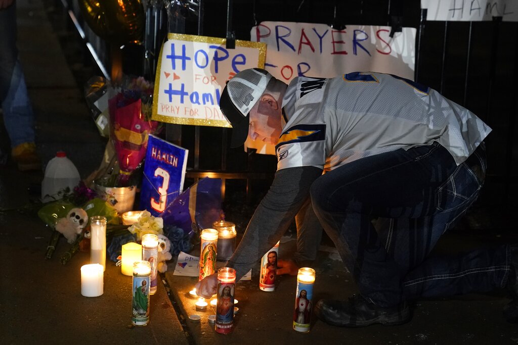 Brandon Metzger lights candles before a prayer vigil for Buffalo Bills