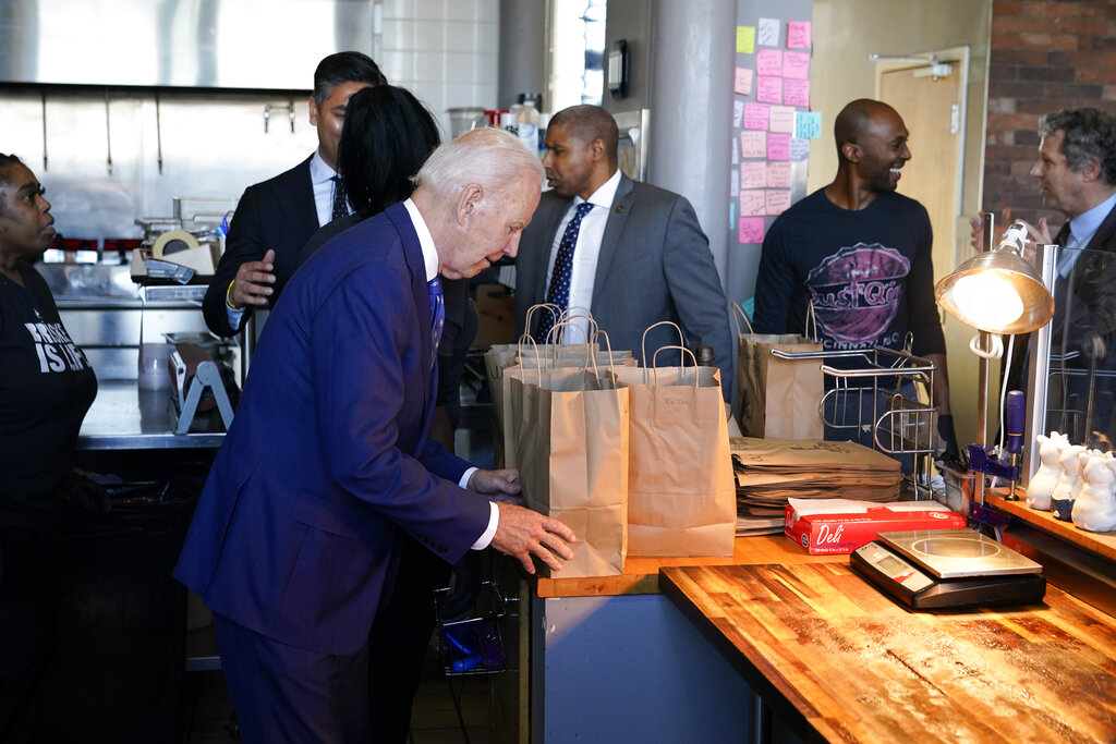 President Joe Biden looks at his order as he visits Just Q