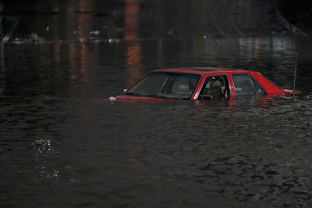 n empty vehicle is surrounded by floodwaters on a road in Oakland, Calif.