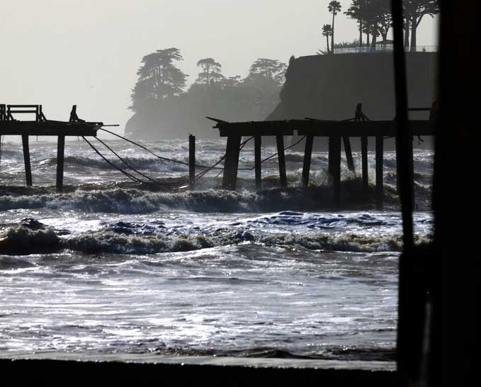 Waves in the Monterey Bay batter the storm-damaged Capitola Wharf in Capitola, Calif.