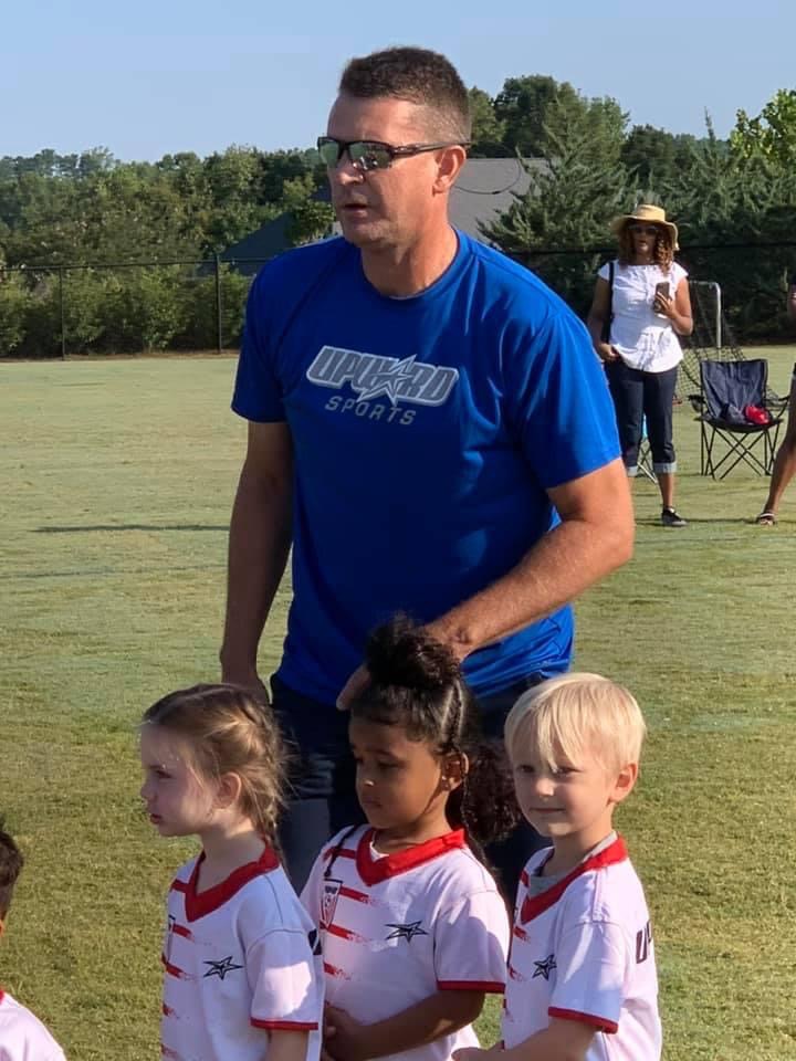 Kevin Drake with children on playing field