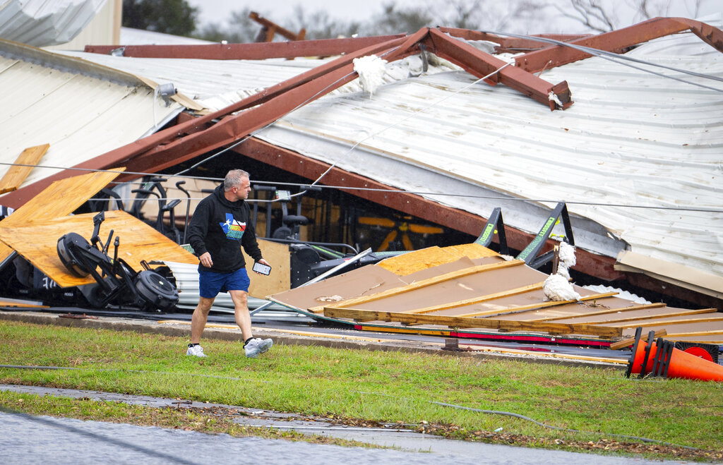 A man walks by a former CrossFit gym that collapsed where a tornado was reported to pass in Pasadena, Texas