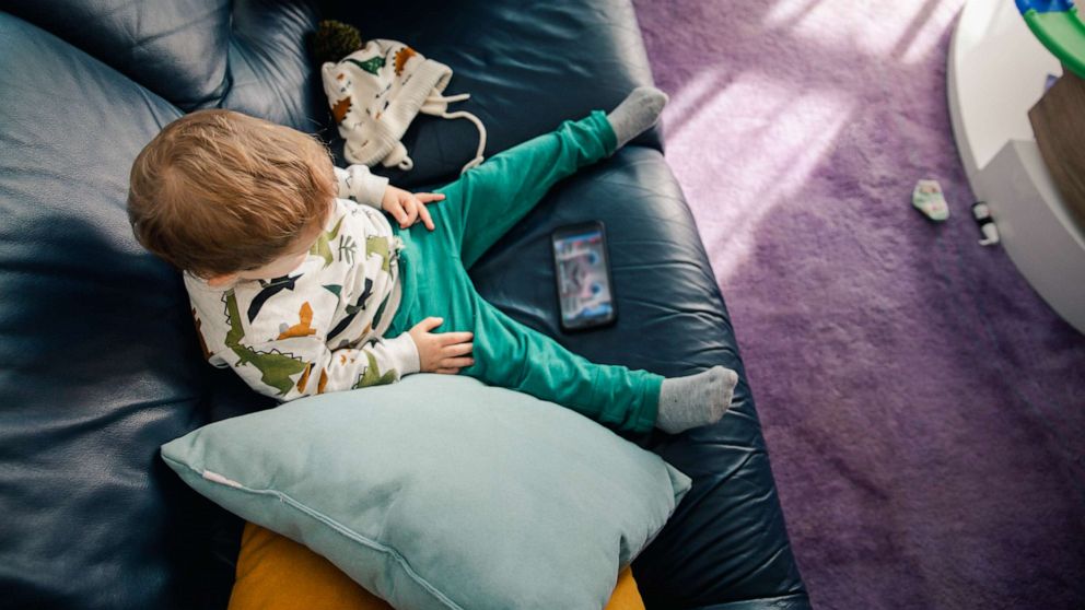 Toddler with cell phone on a couch