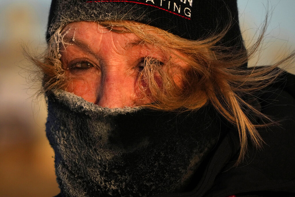 Frost clings to the hair of Joyce Love as she looks at arctic sea smoke on the coast of South Portland, Maine, Saturday, Feb. 4, 2023. The morning temperature was about -10 degrees Fahrenheit. 