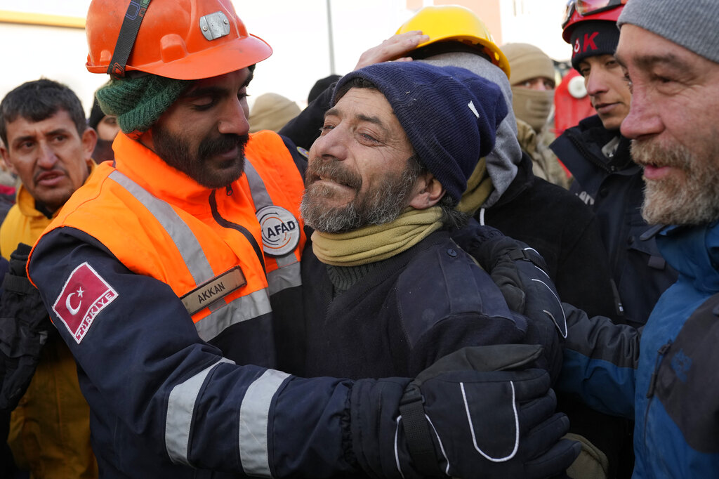 Volunteers and rescue team members celebrate after rescuing Melisa Ulku, 24, alive from a destroyed building in Elbistan, Turkey