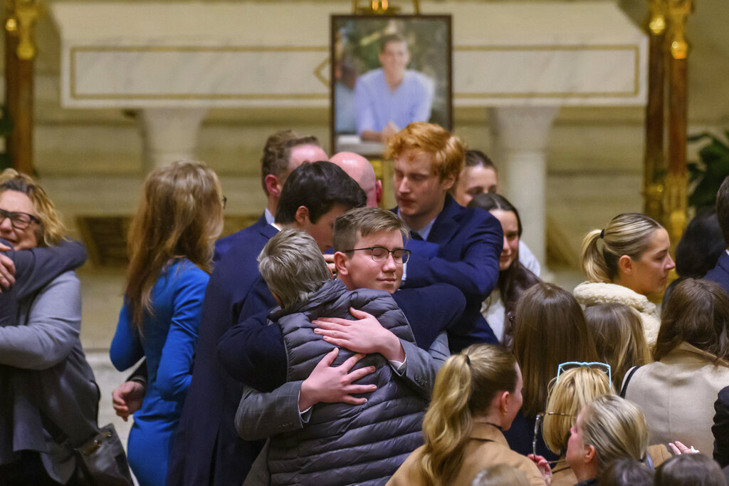 Friends and supporters console each other during a memorial service for Brian Fraser at St. Paul on the Lake Catholic Church in Grosse Pointe Farms, Mich.