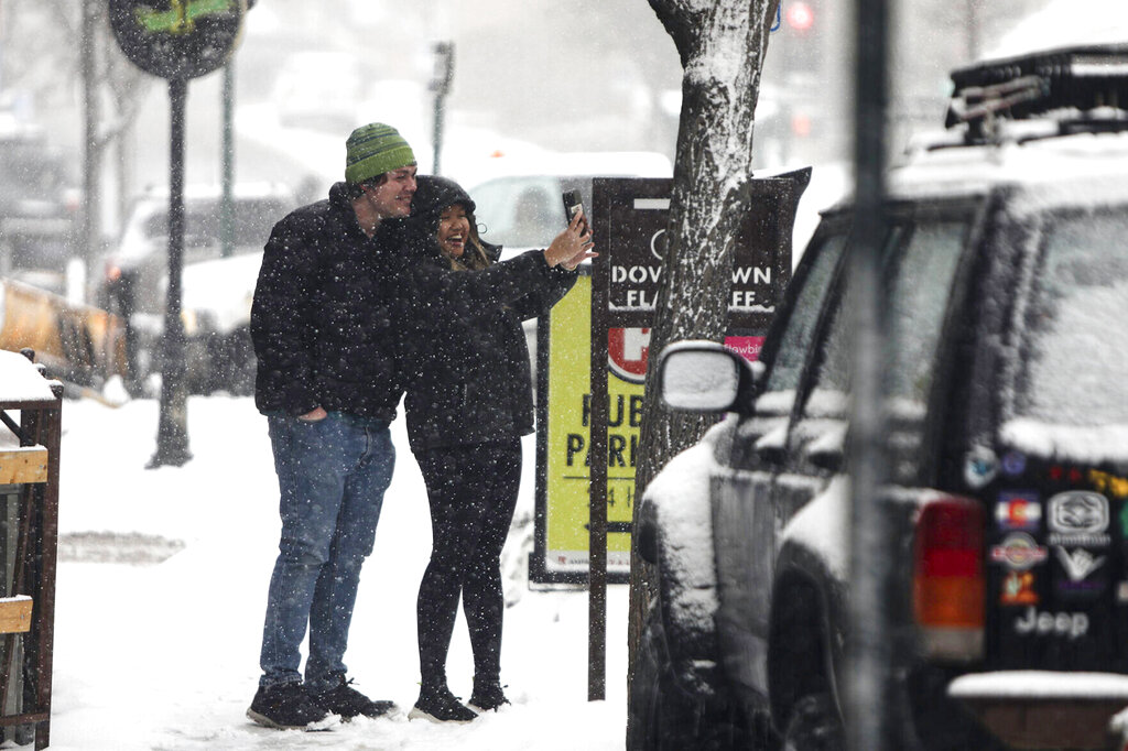 A couple takes a snowy selfie in downtown Flagstaff, Ariz.