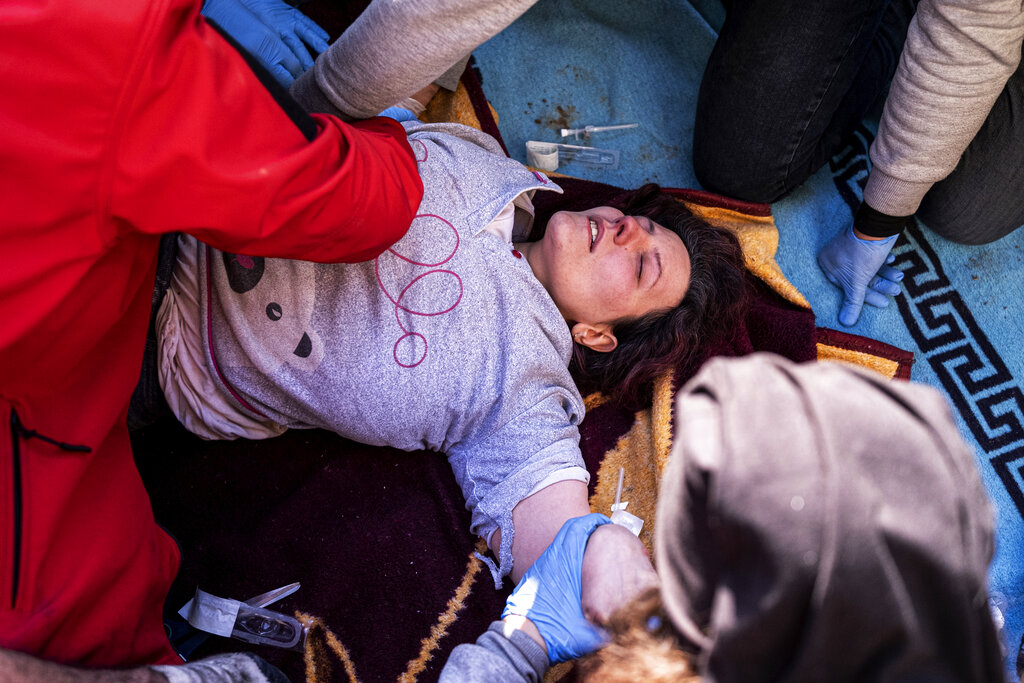 Rescue workers and medics pull out a person from a collapsed building in Antakya, Turkey