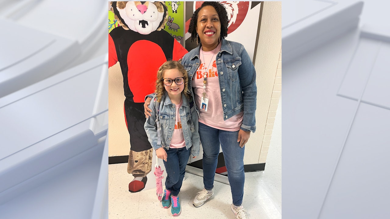Jaime Deigh poses with her student who dressed like her for "Superhero Day."