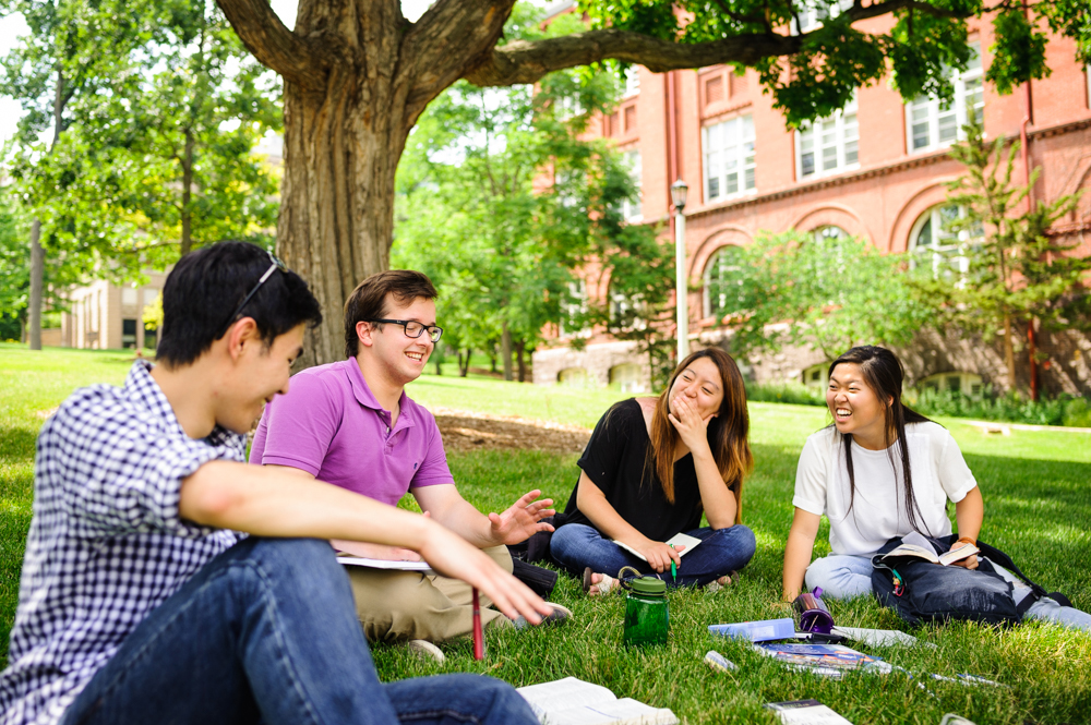 InterVarsity students sitting on college campus lawn