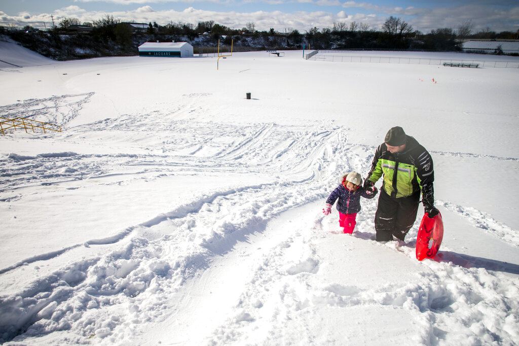 Emma Hart, 5, walks up to the top of the hill hand-in-hand with her father Ryan Hart