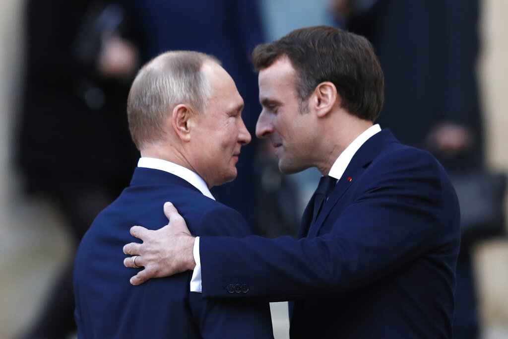 French President Emmanuel Macron, right, welcomes Russian President Vladimir Putin 