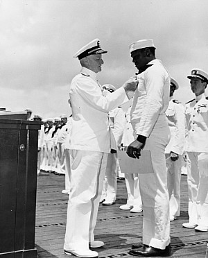 May 27, 1942, Adm. Chester Nimitz awards the Navy Cross medal to Mess Attendant 2nd Class Doris Miller