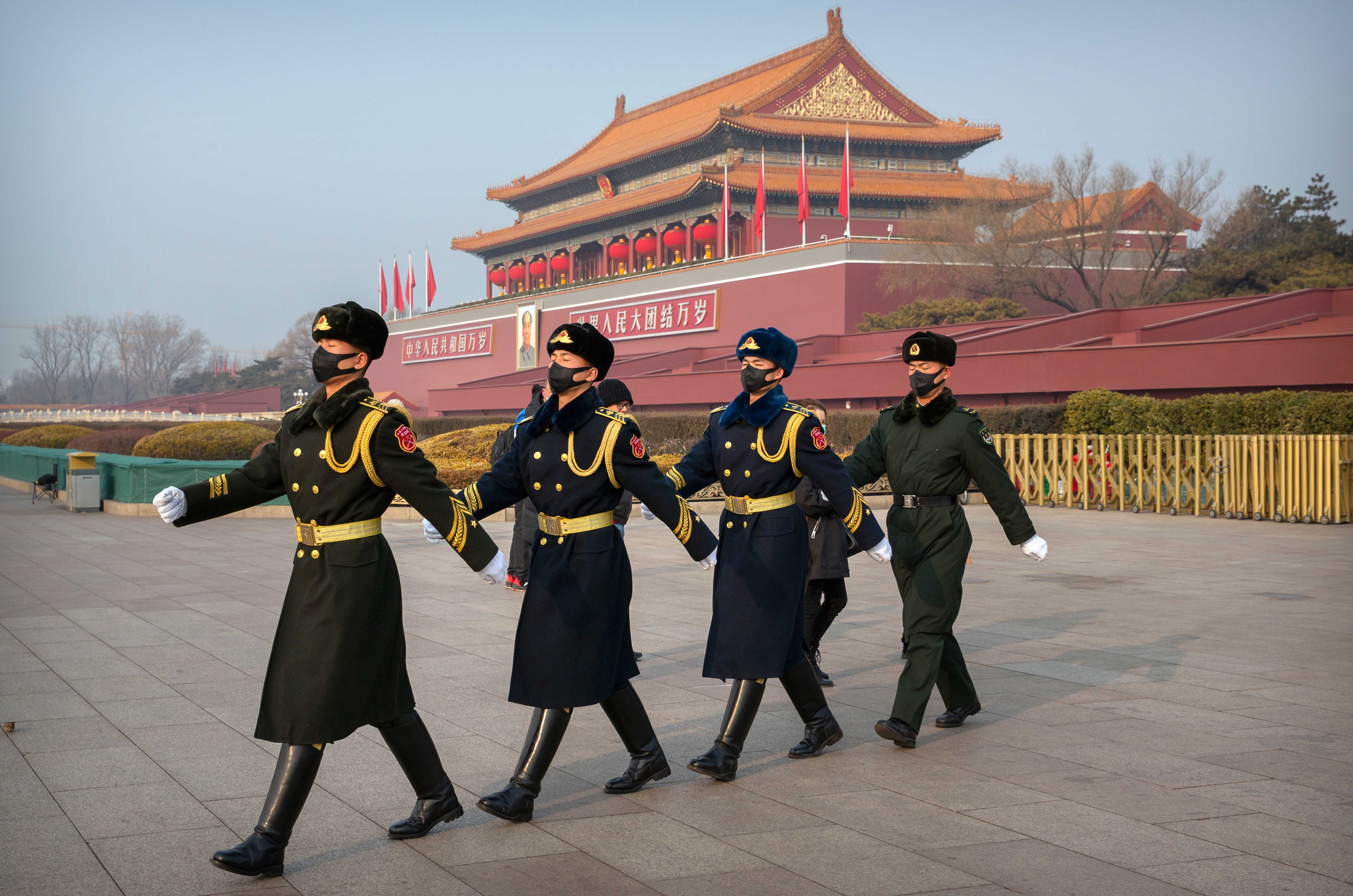 Security officials march in formation near Tiananmen Gate